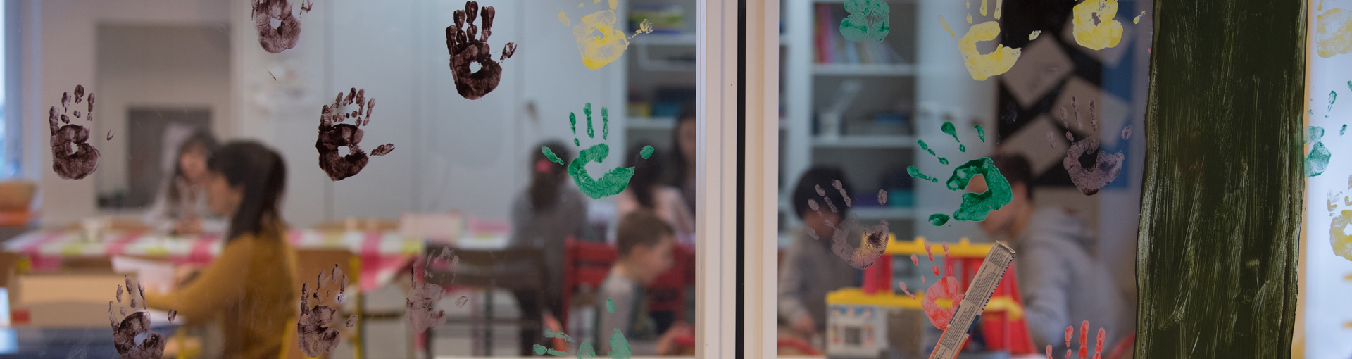 Une structure d'accueil vue de l'extérieur avec des peintures de mains d'enfants