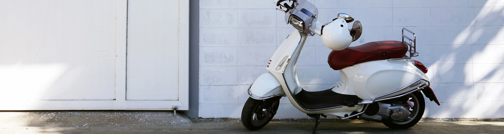 Un scooter blanc contre un mur