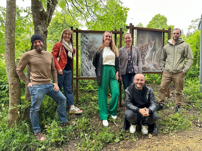 Le photographe et les partenaires posent devant des photos