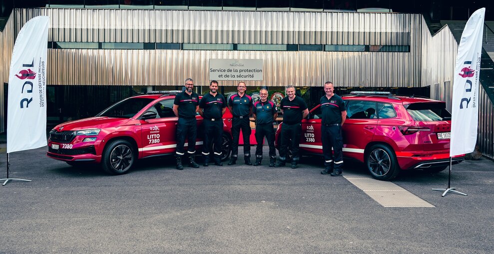 Les deux véhicules rouges et les responsables de secteur