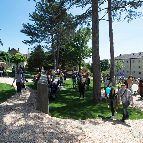 Le jardin Hermann Russ à Serrières, sous le soleil, avec une foule de gens.