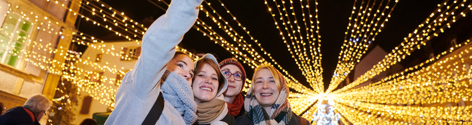 Un groupe de jeunes prend un selfie sous le chapiteau lumineux de la place des Halles
